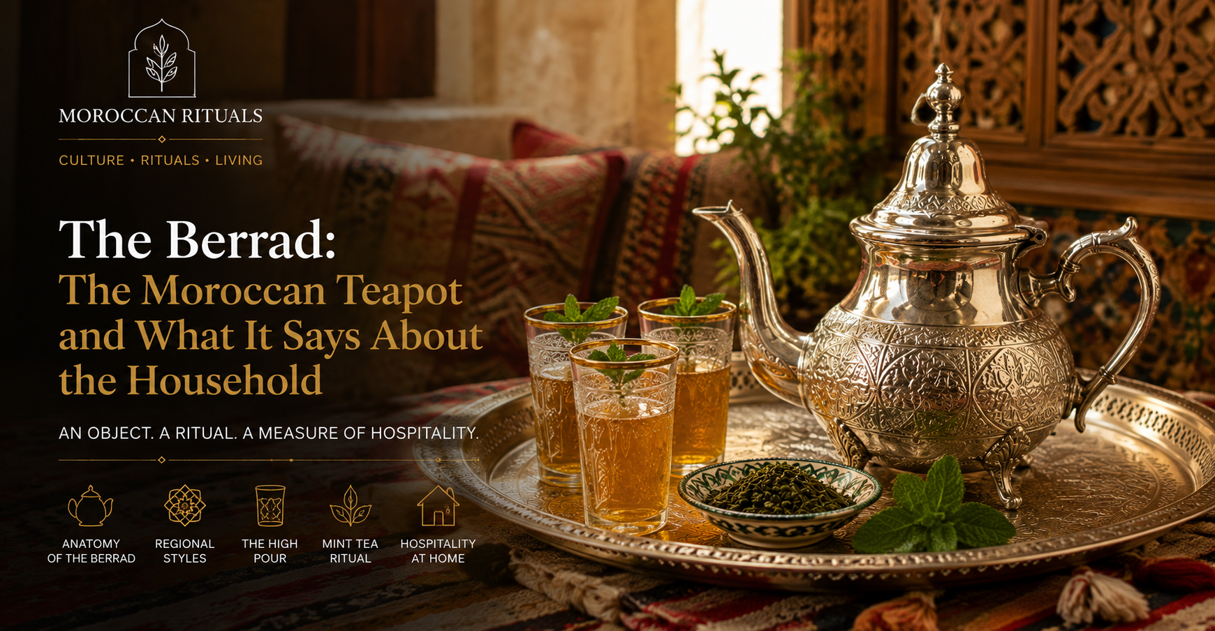 A tall silver-plated Moroccan berrad on a low round tray, its curved spout catching the afternoon light, with three small glasses arranged beside it and a small dish of loose green tea and mint sprigs waiting to be prepared.
